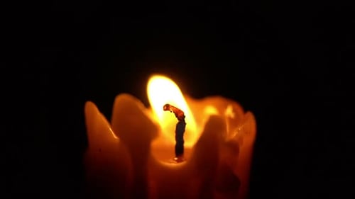 Burning Candle Providing Light in the Dark