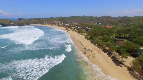 Aerial view faraway of a man running on an empty beach, Indonesia.