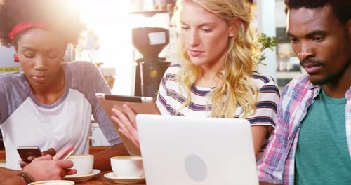 Young Adults Working Together in Cafe with Technology
