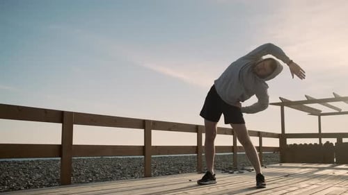 Körperbeugungsübungen beim Outdoor-Training bei Sonnenuntergang