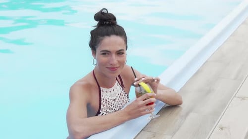 Beautiful Happy Woman Enjoying Cocktail at the Swimming Pool