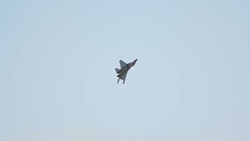 A Green Military Reactive Plane Flying in the Sky and Performing a Show with Pirouettes