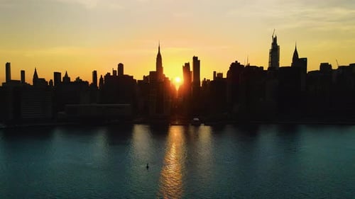 Skyscrapers' Silhouette, aerial sliding shoot of New York City at golden hour, with the Sun crossing
