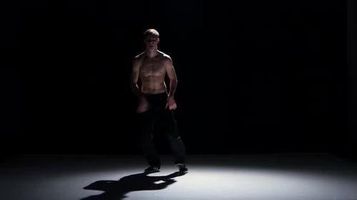 Breakdance Dancer mit nacktem Torso Dance, Flip machen und dann auf Schwarz tanzen, Schatten