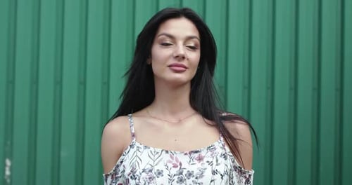 Elegant Woman Posing Against a Green Background