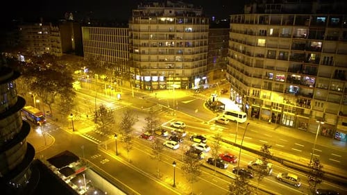 City Intersection at Night with Cars and Buildings