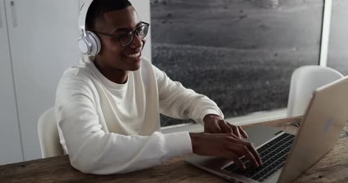 Young Adult Using Laptop in Bright Home Setting