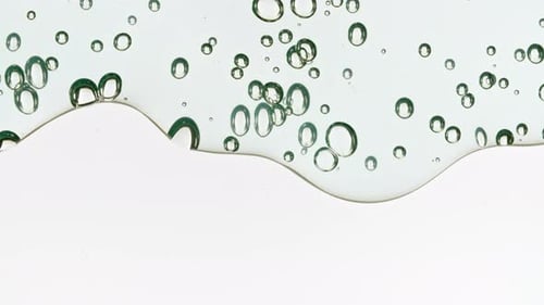 Transparent Blue Cosmetic Gel Fluid with Bubbles Flowing Down on Surface