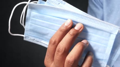 Man Hand Holding Surgical Face Mask, Close Up