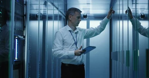 Technician Works on a Tablet in a Data Center