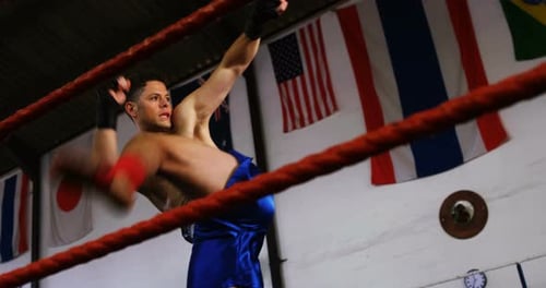 Boxer Kicking in Boxing Ring with Flags