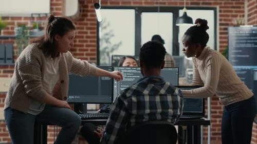 System Engineer Sitting on Desk Discussing with Mixed Team of Coders About Ai Innovation