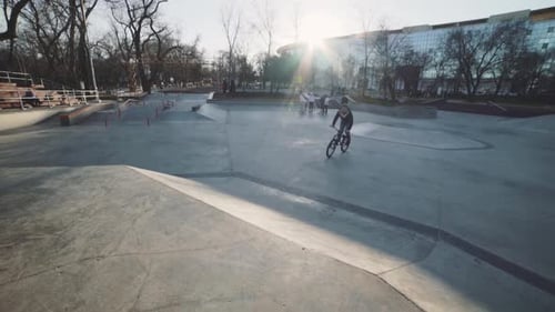 MTB Bicycle Rider Does Various Tricks While Riding in Skatepark