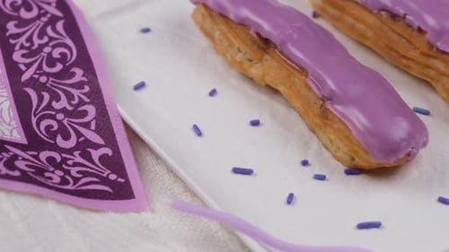 Eclairs with Purple Icing on Plate