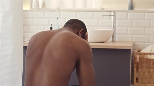 Man with Head in Hands in Bathroom