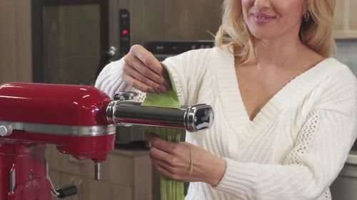 Woman Making Green Pasta in Kitchen with Mixer