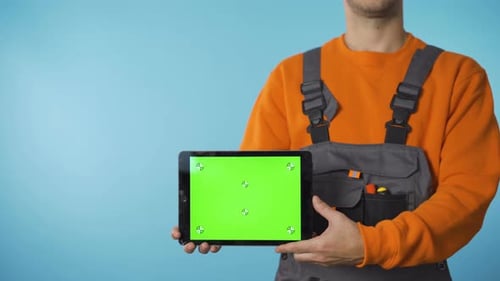 Close Shot of Repairman Hands Holding a Tablet with Green Screen.