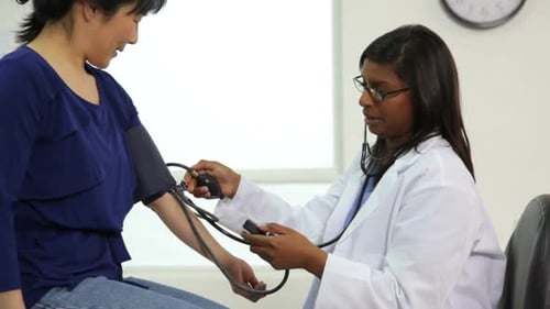 Doctor Measures Patient Blood Pressure in Office