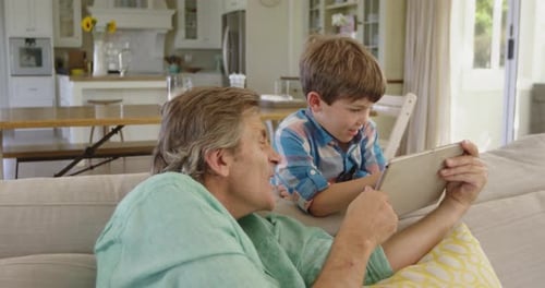 Grandfather and Grandson Using a Tablet on Couch