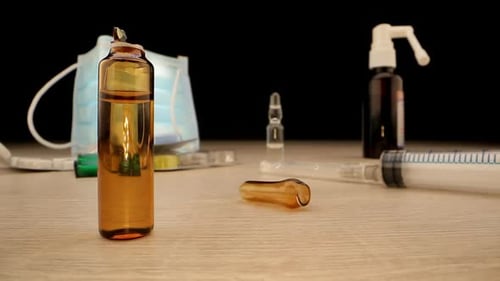 Opened Vial with Vaccine Near Syringe Syrup and Pills