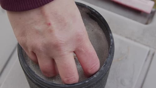 Gestein wird aus dem Fass in Sand gezogen, um es während des Taumelprozesses zu untersuchen
