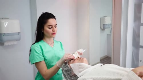 Woman Provides Facial Treatment in Clinic