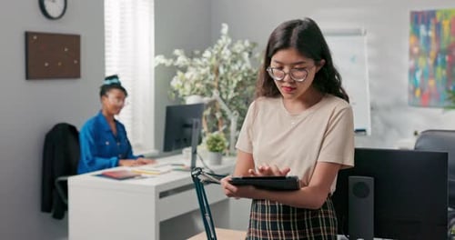 Accounting Department Manager Beautiful Girl with Glasses Holds Tablet in Hand Checks Progress of