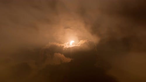 Partielle Sonnenfinsternis mit Strahlbildung durch die Wolke.