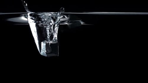 Zeitlupenwürfel fällt durch Wasser