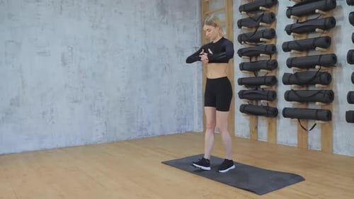 Woman Doing Standing Toe Touches in Gym