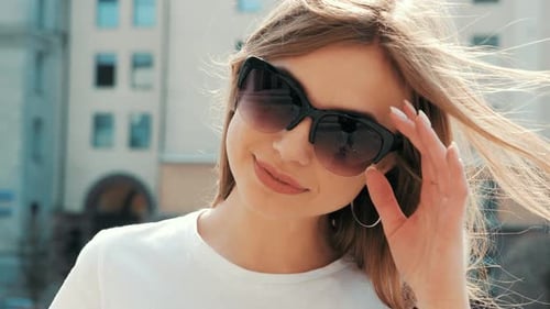 Smiling Woman Posing in Sunglasses on City Street