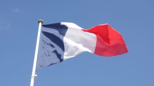 French Flag Waving Proudly Against Blue Sky