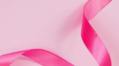 Bright pink ribbon on a light pink backdrop