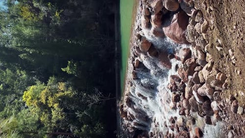 Mountain river with cascades of water and waterfalls in forest.