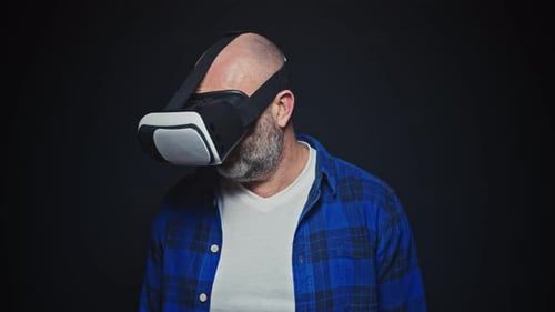 Mature Man Using VR Headset for Virtual Reality in Studio