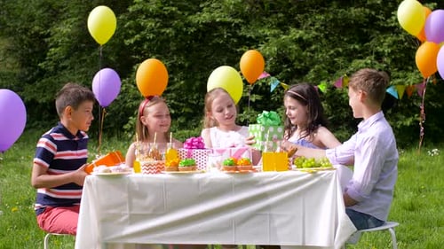 Children at Outdoor Birthday Party Exchanging Gifts