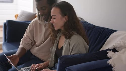 Happy Couple Relaxing at Home with Laptop