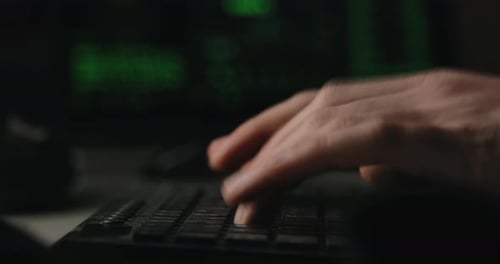 Hacker tippt Tasten auf einer Tastatur in seinem Zimmer