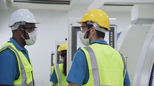 Grupo de trabajadores de la diversidad que usan mascarillas protectoras en la fábrica de producción debido al covid-19.