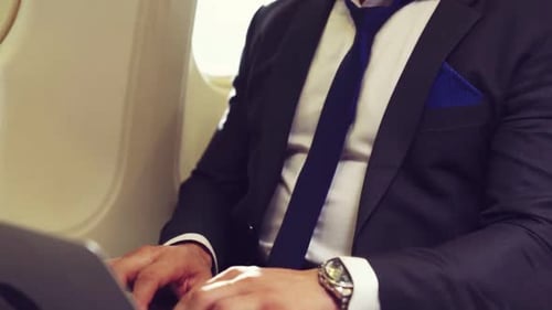 Man Works on Laptop Inside an Airplane