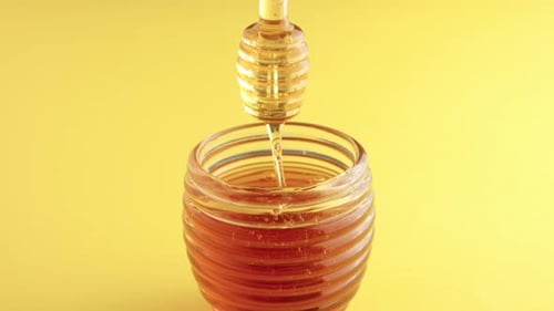 Closeup of Honey Spoon with Pouring Honey