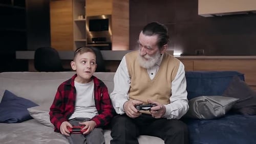 Grandfather and Grandson Play Video Games at Home