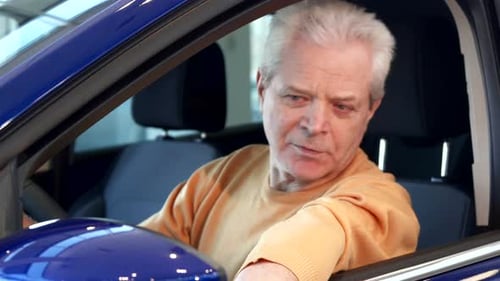 Smiling Senior Man Giving Thumbs Up in Car