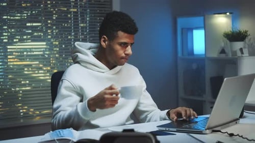 Young Adult Man Working Late Night on Laptop