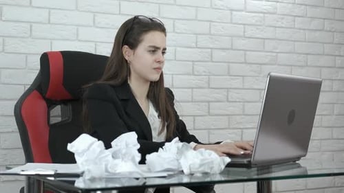 Müdes Mädchen im Büro streut zerknitterte Dokumente.