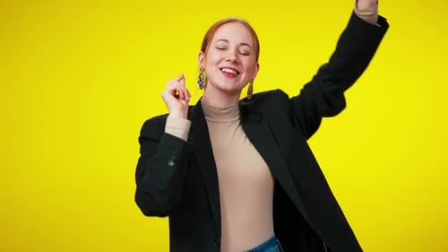 Cheerful Woman Dancing on a Bright Yellow Background
