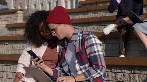 Students Studying Outdoors Using Devices