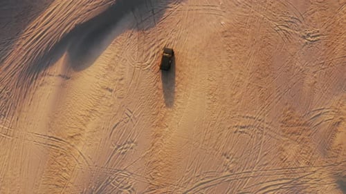 SUV Car Driving Along an Edgy Hillside of a Yellowish Beautiful Dune