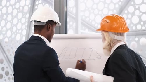 Architect and Engineer Looking at Scketch Blueprint at Office and Discussing Project