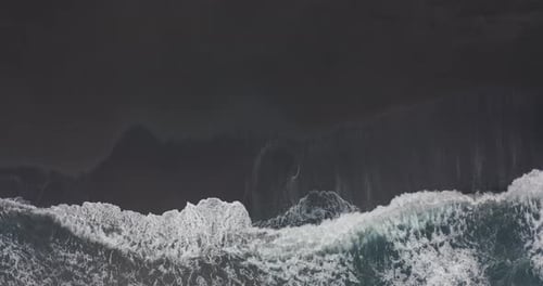 Aerial View. Stunning Aerial Footage of Waves Breaking Against Beautiful Icelandic Black Sand Beach